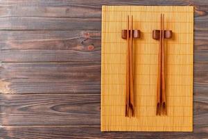 two sets of sushi chopsticks on wooden bamboo background, top view photo