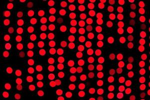 Unfocused abstract red bokeh on black background. defocused and blurred many round light photo