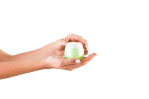 Female hand holding cream bottle of lotion isolated. Girl opening jar cosmetic products on white background photo