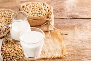 Soy milk in a glass with soybeans on a wooden table Organic breakfast, high protein, healthy, agricultural products, vegetarian photo