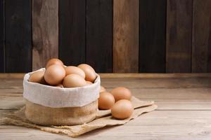 Fresh organic chicken eggs from the farm on a rustic wooden table. photo