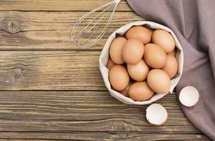 Fresh organic chicken eggs from the farm on a rustic wooden table. photo