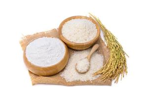 vista superior de harina de arroz, trigo en un bol de madera y espigas de arroz aisladas en fondo blanco.