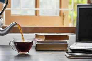 la taza de café se coloca sobre el escritorio. oficina o en casa con un teclado de computadora portátil tablet pc foto