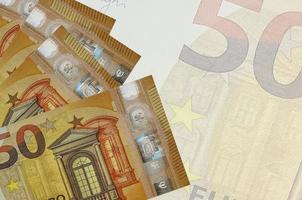 Los billetes de 50 euros se encuentran apilados sobre el fondo de un gran billete semitransparente. fondo de negocios abstracto foto