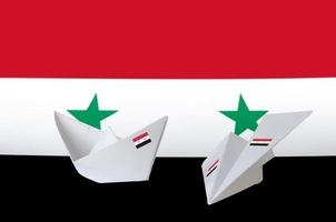 bandera siria representada en avión y barco de origami de papel. concepto de artes hechas a mano foto