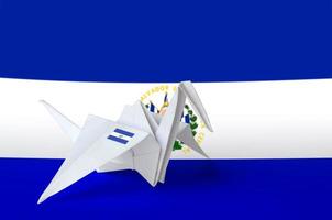 El Salvador flag depicted on paper origami crane wing. Handmade arts concept