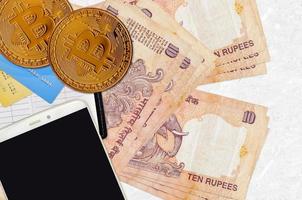 10 Indian rupees bills and golden bitcoins with smartphone and credit cards. Cryptocurrency investment concept. Crypto mining or trading photo