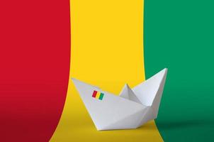 Guinea flag depicted on paper origami ship closeup. Handmade arts concept photo