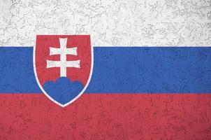 Slovakia flag depicted in bright paint colors on old relief plastering wall. Textured banner on rough background photo