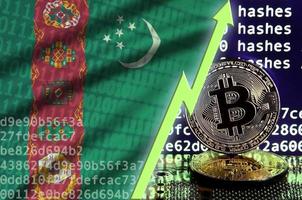 bandera de turkmenistán y flecha verde ascendente en la pantalla de minería de bitcoin y dos bitcoins dorados físicos foto