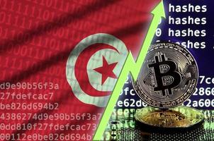 Tunisia flag and rising green arrow on bitcoin mining screen and two physical golden bitcoins photo