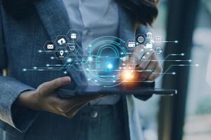 Cybersecurity and privacy concepts to protect data. Lock icon and internet network security technology. Businessman protecting personal data on smart phone with virtual screen interfaces. photo