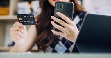 Woman hands holding and using cradit card for shopping online. photo