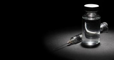 4k Punkt beleuchtetes medizinisches Impfstofffläschchen, Spritze dreht sich auf schwarzer Oberfläche video