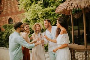 Group of young people cheering and having fun outdoors with drinks photo