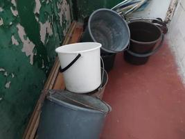 Plastic buckets lie on the balcony of the house photo