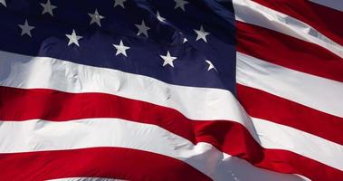 langzaam beweging echt Amerikaans vlag golvend in wind tegen een diep blauw lucht video