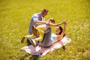 Happy young family with cute little daughter having fun in the park on a sunny day photo