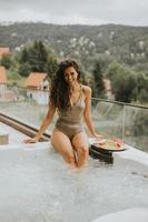 Young woman enjoying in outdoor hot tub on vacation photo