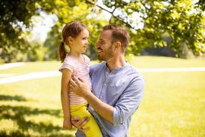 padre con hija divirtiéndose en el parque foto