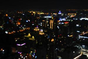 luz de colores borrosa de la construcción de casa o casa, estructura, vehículo y transporte en la ciudad de bangkok en la noche como fondo. vida abstracta en el fondo de pantalla del país de Tailandia. foto