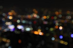 Blurred colorful light Bokeh of Bangkok on dark night for background. Defocused technique. Abstract wallpaper of life in city or country concept. photo