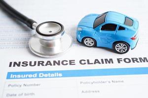 estetoscopio en el formulario de accidente de reclamo de seguro, concepto de préstamo de automóvil, seguro y tiempo de arrendamiento. foto