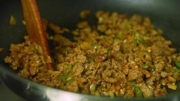 Mix chopped onion, chopped pepper and chorizo meat. Fry in a pan. Macro shooting video