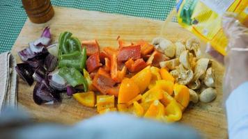 tiro en el control deslizante de verduras picadas y frescas. pimientos de varios colores y champiñones con cebolla roja video