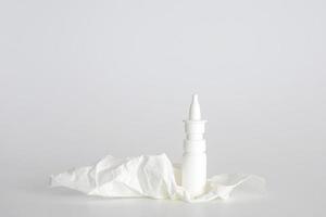 botella de spray nasal de plástico blanco sobre fondo blanco. recipiente de aerosol nasal, solución de agua salina para el tratamiento de la congestión nasal. secreción nasal, resfriados. espacio libre, espacio de copia. foto