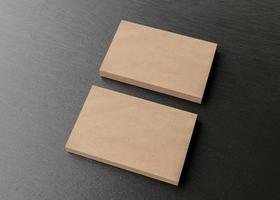 Blank brown cardboard business cards on dark wooden table. Mockup for branding identity. Two stacks, to show both sides of card. Template for graphic designers. Free space, copy space. 3D rendering. photo