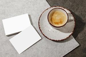 Blank white business cards on the table, with cup of coffee. Mockup for branding identity. Possibility to show both sides of card. Template for graphic designers. Free space, copy space. photo