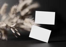 Blank white business cards on black background with dried plants. Mock up for branding identity. Two cards, to show both sides. Template for graphic designers. Free, copy space. 3D rendering. photo