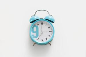 Blue alarm clock on the white background. Morning, time to wake up. photo