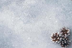 Pine cones on a gray background with the effect of falling snow. Texture subtext. photo