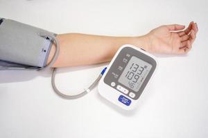 Woman measures blood pressure, with copy space on white background photo