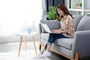 Beautiful women wear casual clothes using laptops on the sofa. photo