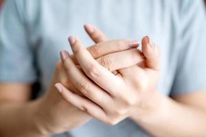 Woman having pain in knuckles and hands. Health care and medical concept photo