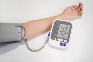 Woman measuring blood pressure with electronic digital tonometer, female hand close up. Arterial hypotension and cardiology concept photo