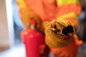 Focus on the fire extinguisher, the man carried the fire extinguisher to put out the fire in the building. photo