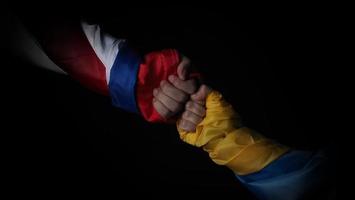 Russian flag and Ukraine flag in hands showing symbol of struggle war photo