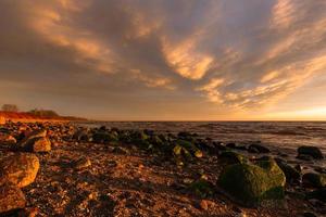 piedras en la costa del mar Báltico al atardecer foto