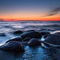 piedras en la costa del mar Báltico al atardecer foto