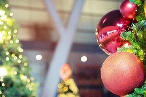 Closeup of bauble colorful variety hanging from a decorated christmas tree on blurred of lights with decorated tree, sparkling and bokeh background. copy space for your text. Christmas Tree Decoration photo