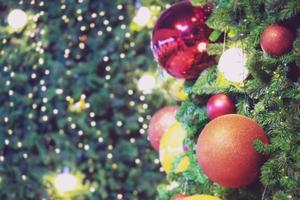 Closeup of bauble colorful variety hanging from a decorated christmas tree on blurred of lights with decorated tree, sparkling and bokeh background. copy space for your text. Christmas Tree Decoration photo