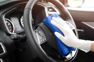lavado de autos, mano de obra guante limpieza consola volante con paño de microfibra azul. prevención de la higiene antibacteriana del brote del virus de la corona.