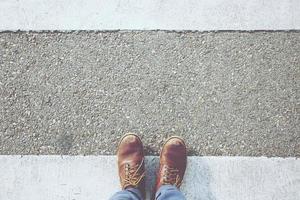 Young man walking crosswalk on the road for safety when people at the junction street of city, Pedestrian safety, Aerial top view. Leave empty space blank to Write a message on road floor. photo