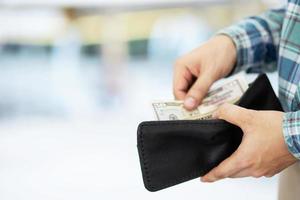 hombre sosteniendo una billetera con dinero foto
