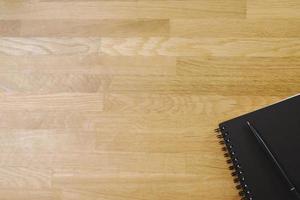 View from above of face sketch notepad color black and a pen on wooden background with copy space. top view blank notebook and text. photo